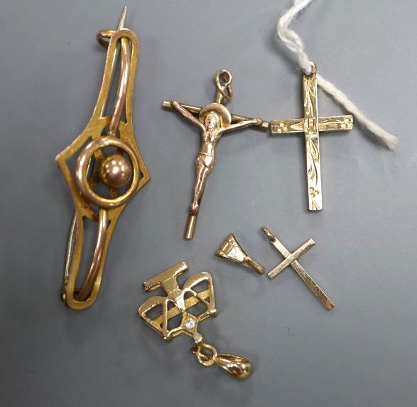 An Edwardian 9ct scroll brooch, 4cm, two 14k small pendants, a 9ct cross pendant and a 12k gold plated pendant,